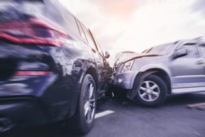 silver SUV crashing into the passenger side of dark colored SUV